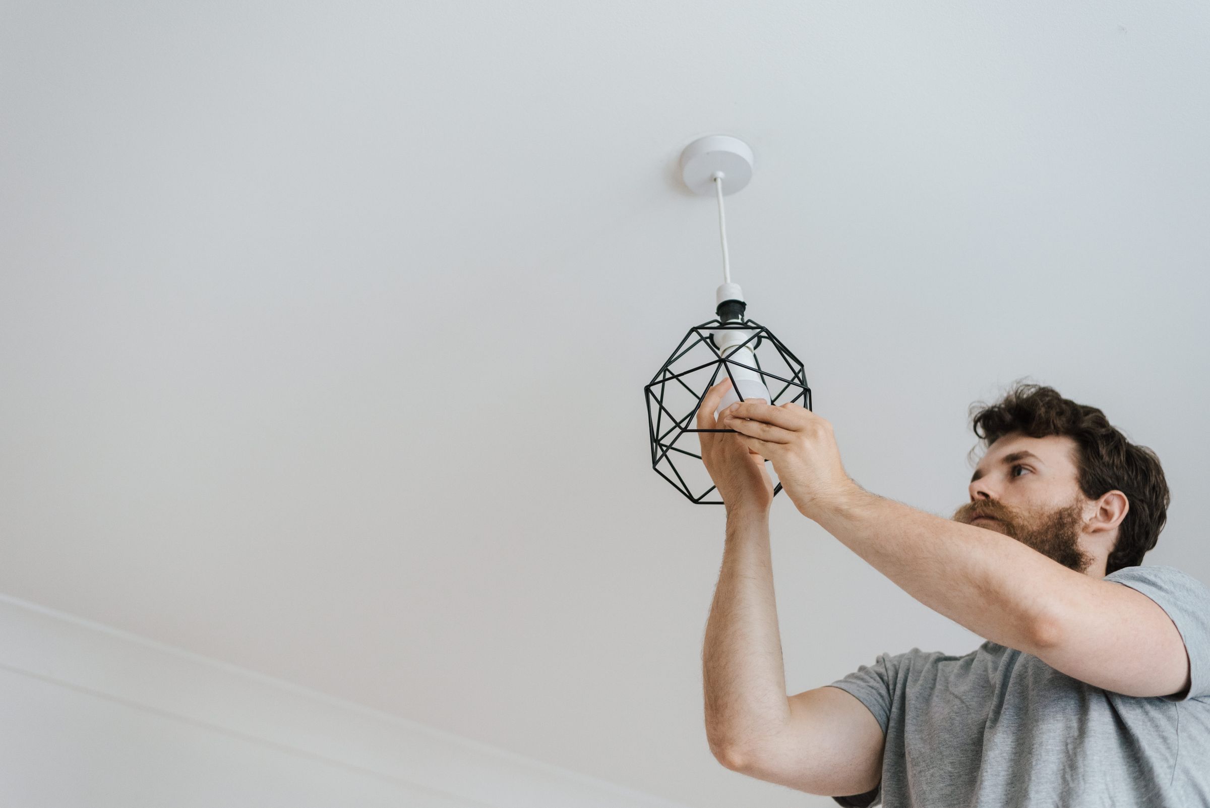Light bulb being screwed into a geometric pendant lamp