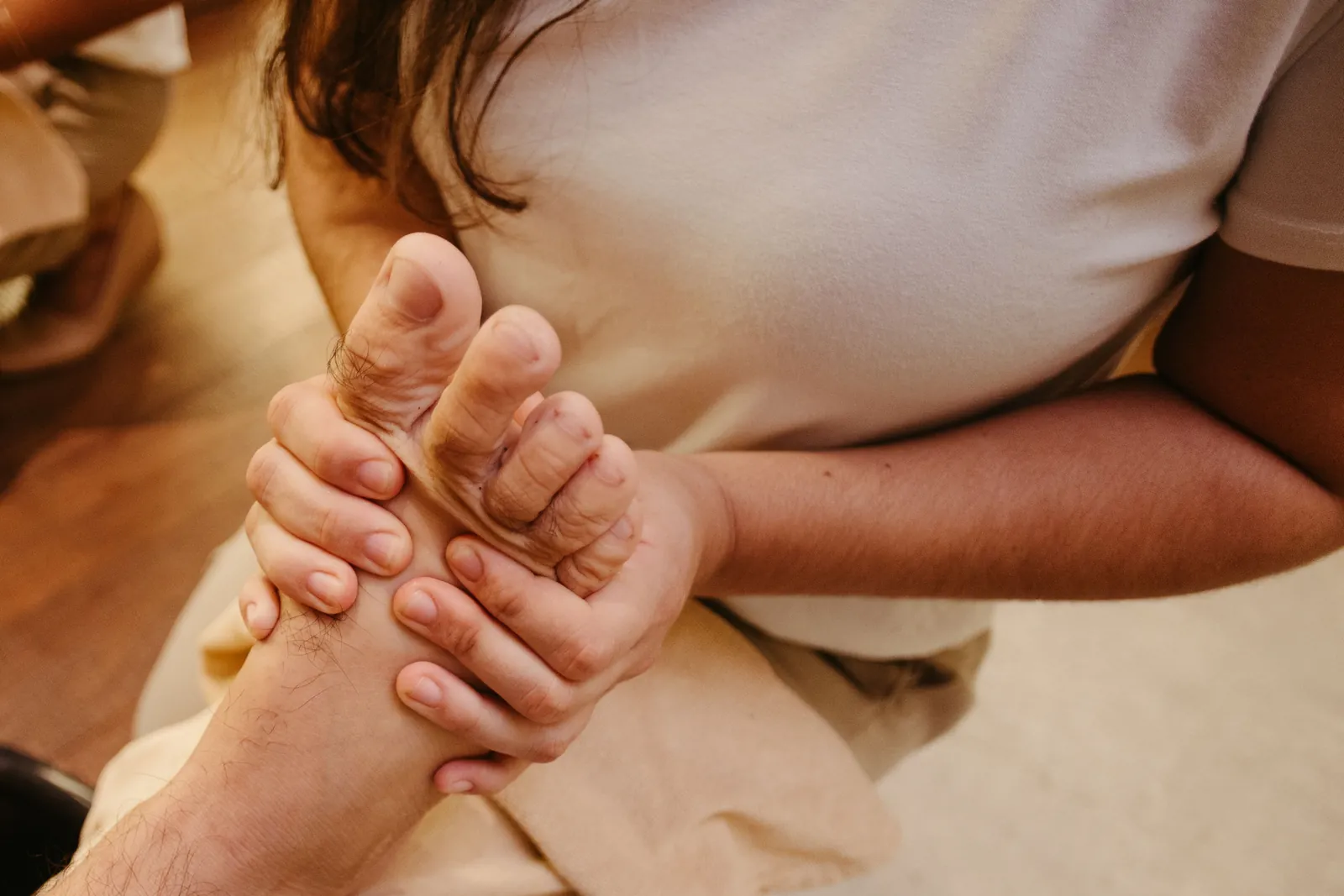 Hands gripping and pressing the sole of a foot.