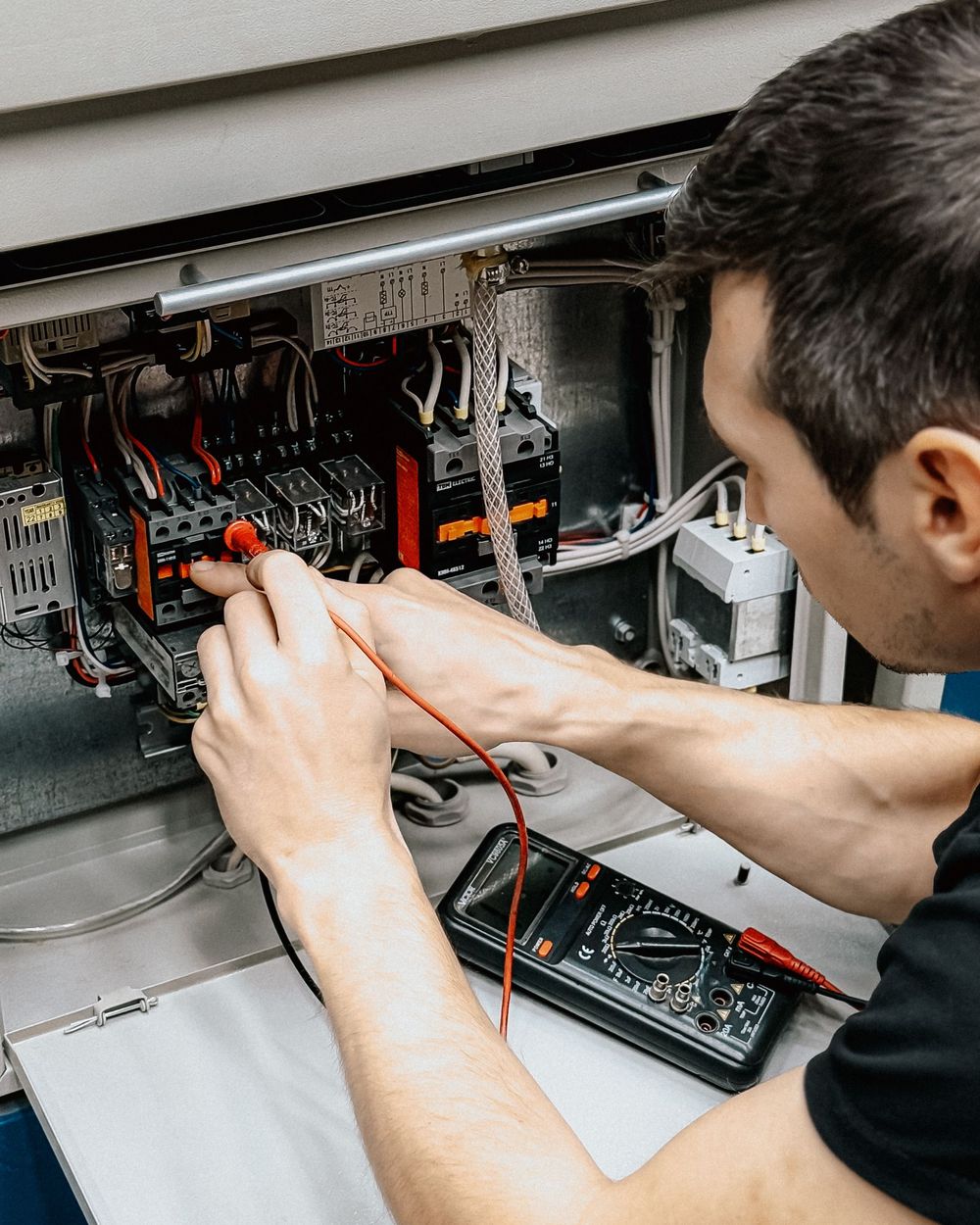 Multimeter in use at an open electrical panel