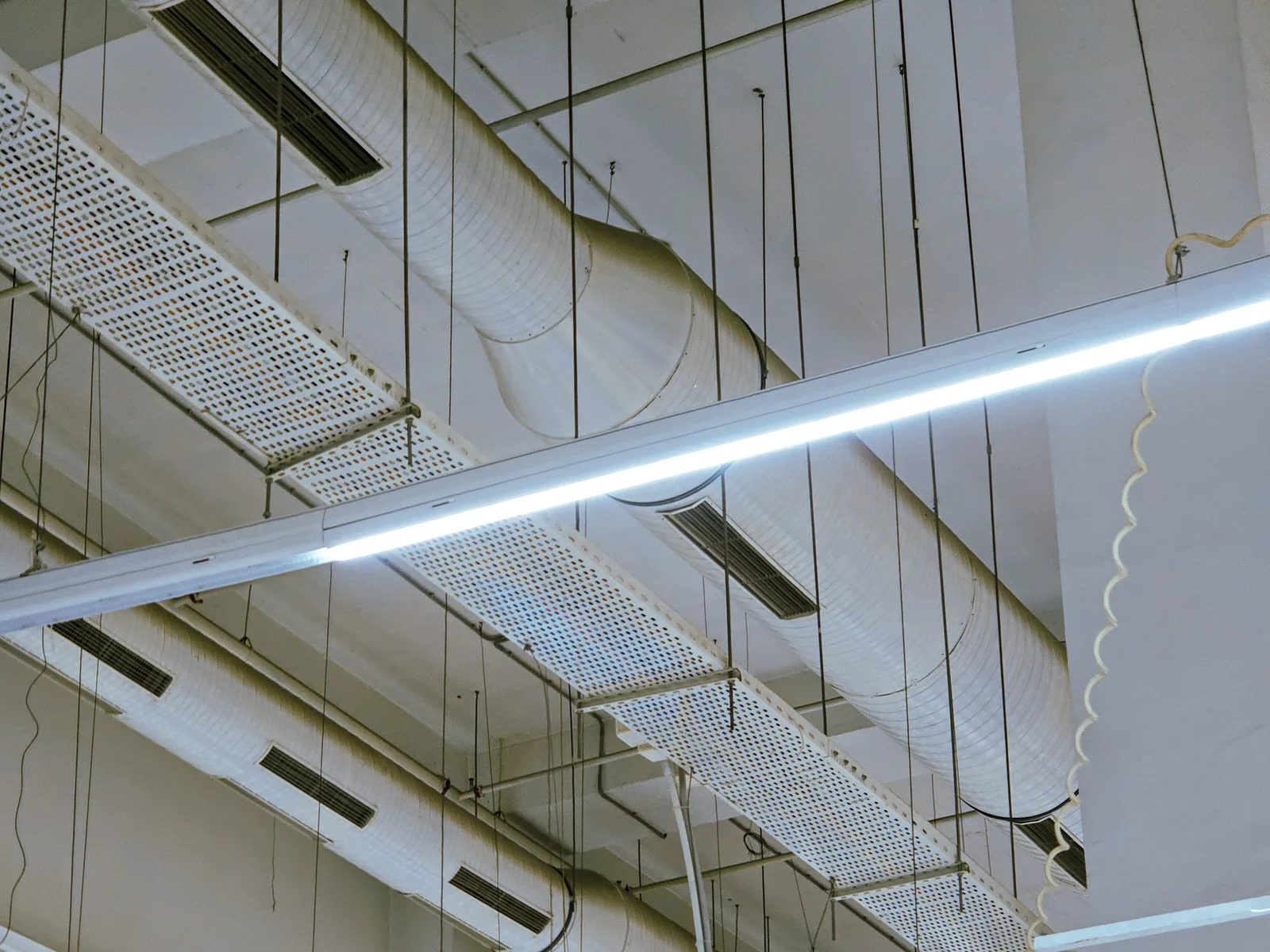 Flexible ducting and ceiling vents running through a building ceiling