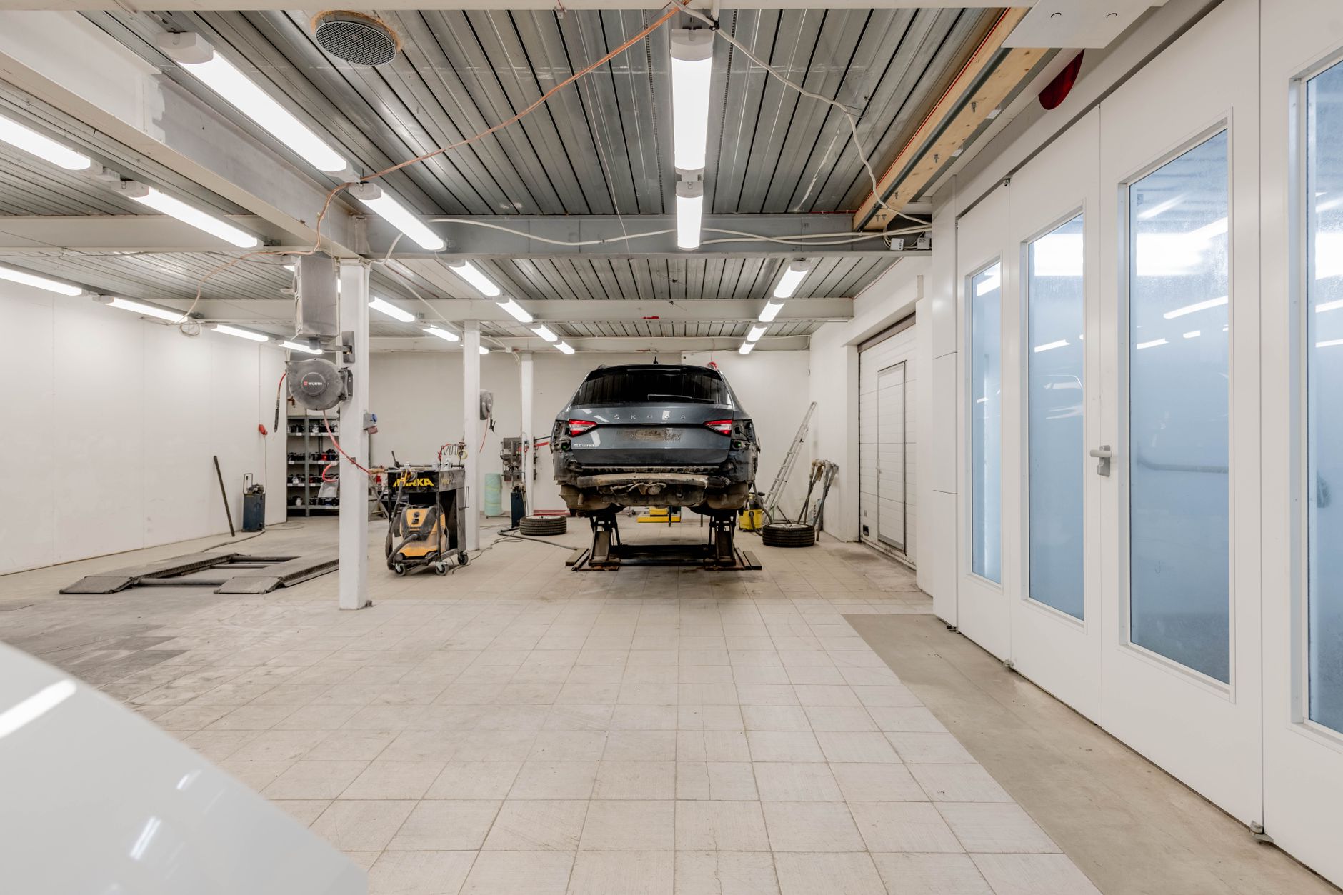 Car on a hydraulic lift in a well-lit repair garage
