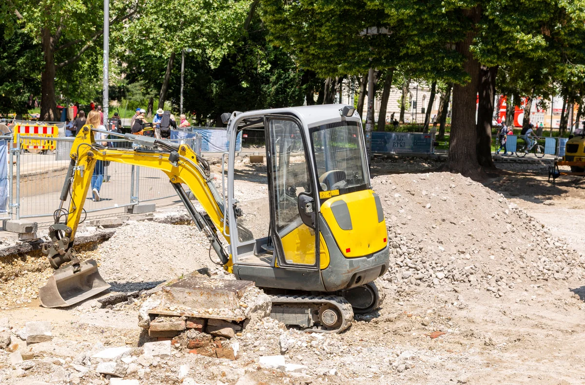 Compact excavator preparing ground at a construction site