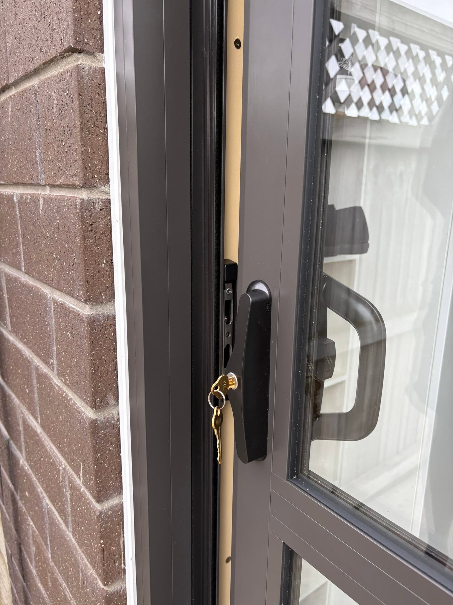 Cream aluminium front door with vertical glass side panels and black hardware