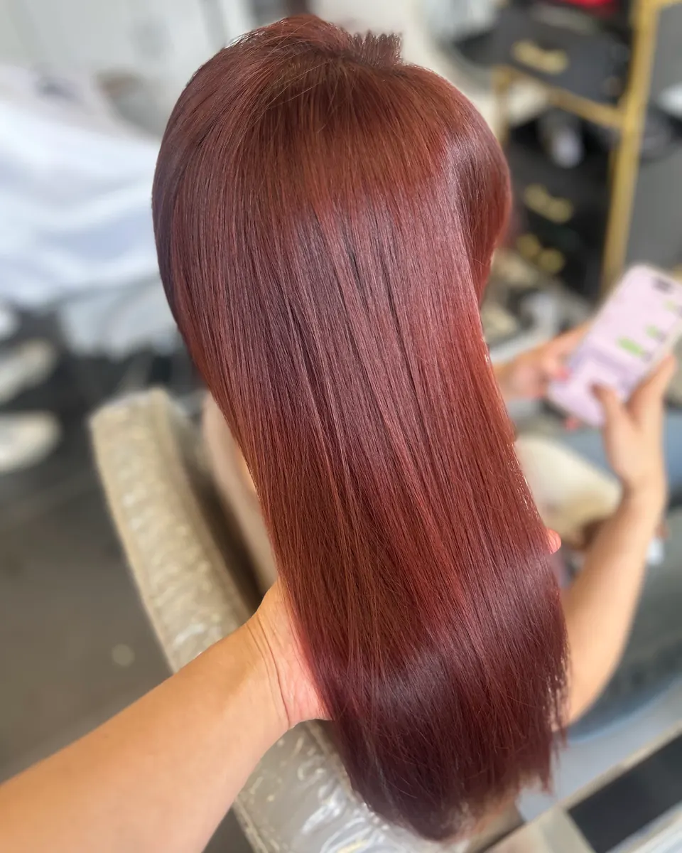 Long, smooth burgundy hair, straight to the ends.