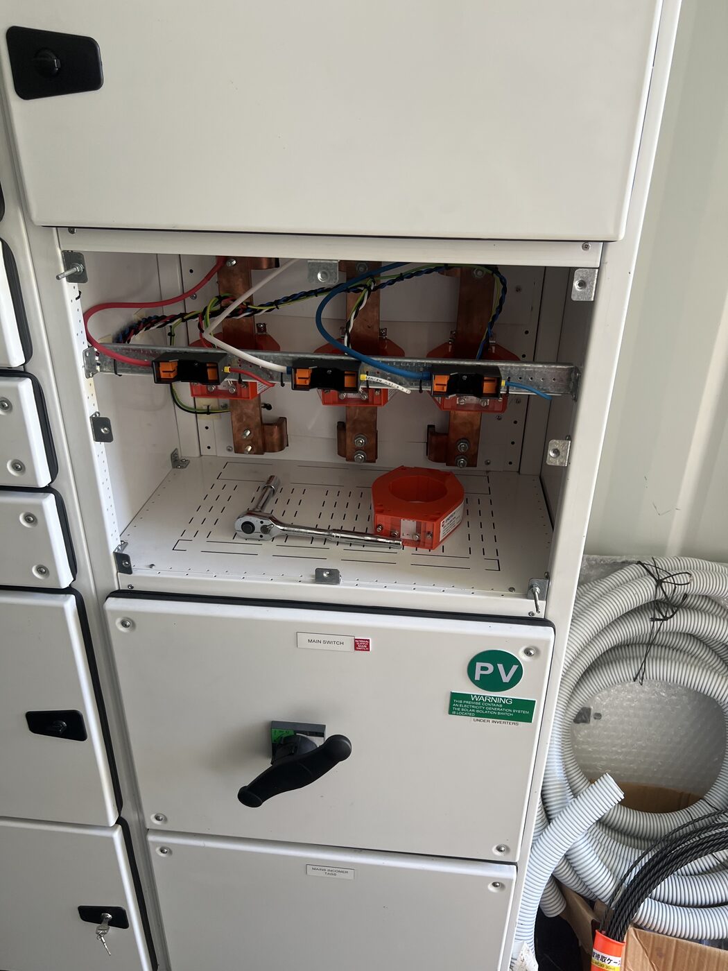 Open electrical switchboard showing busbars and breakers