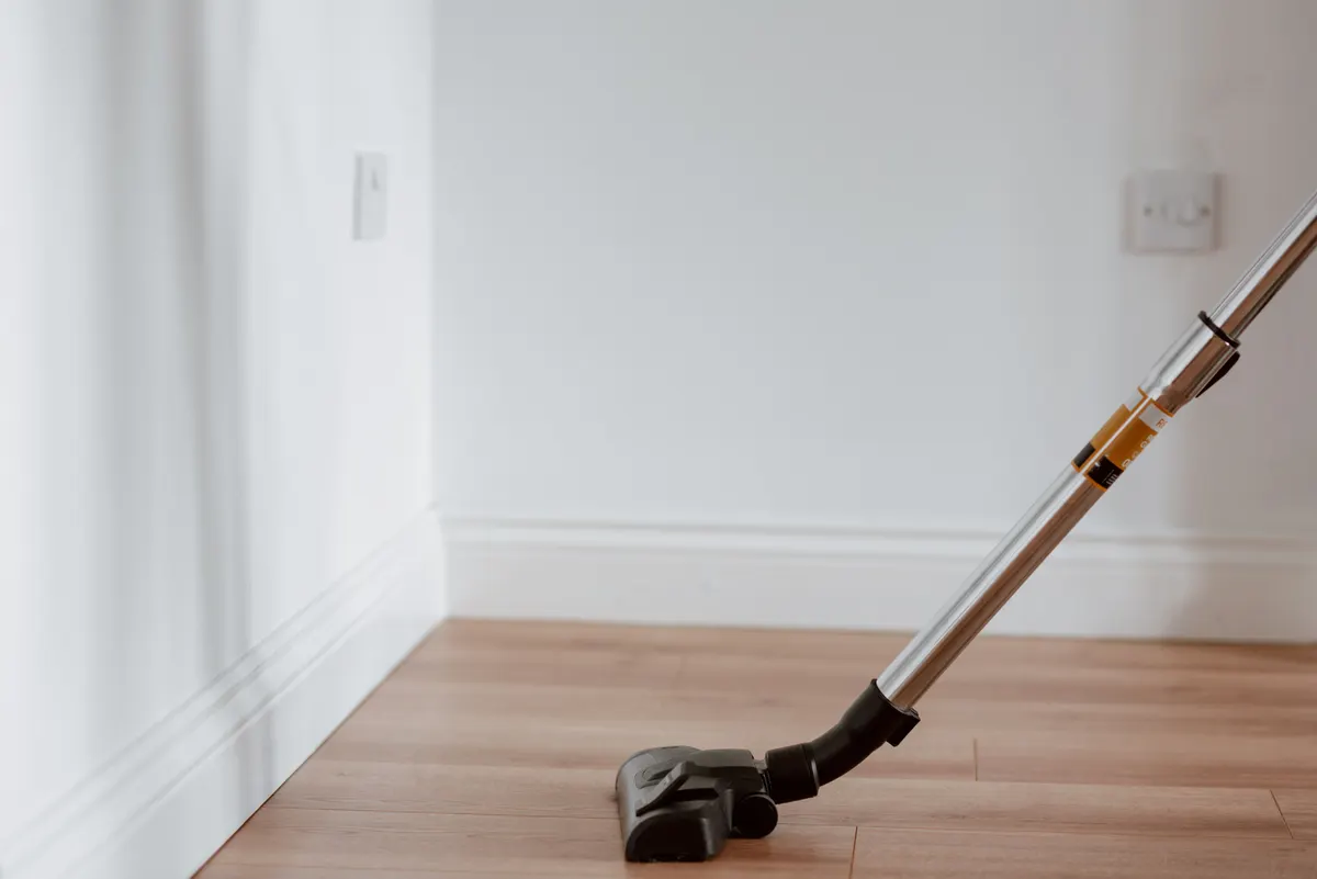 Vacuuming the floor of an empty room.