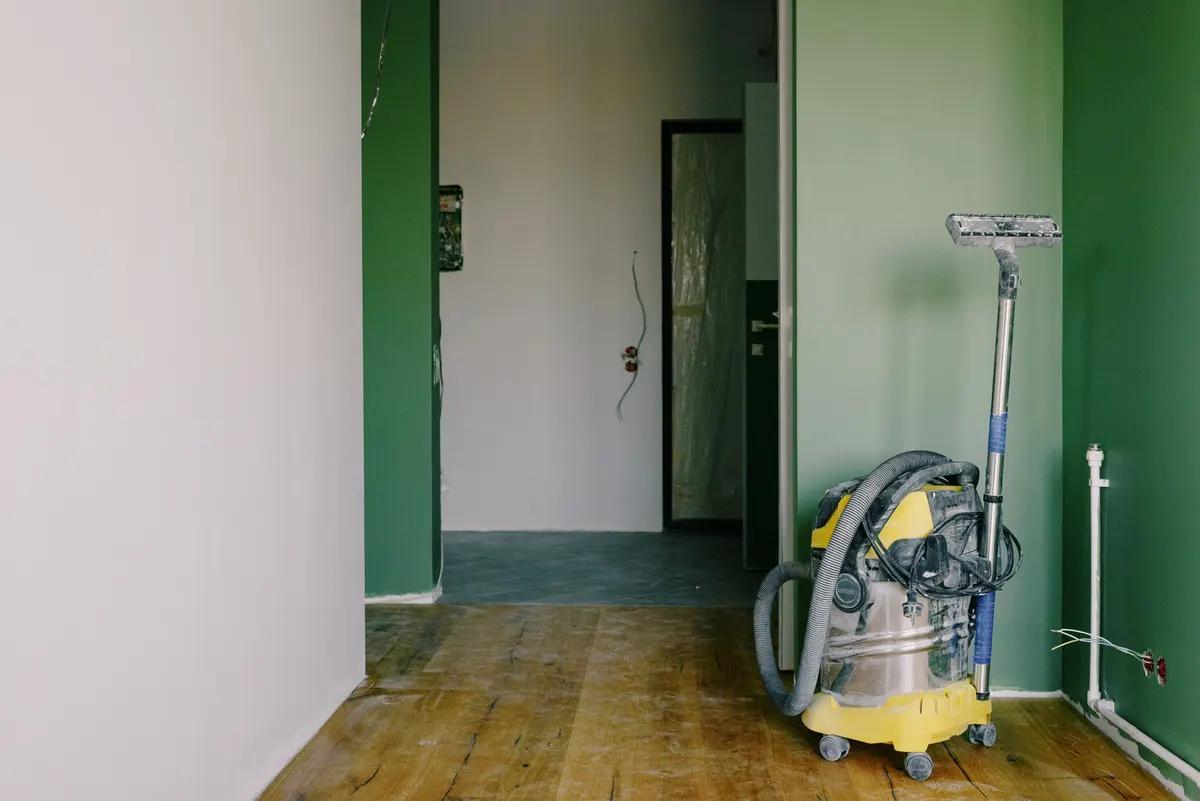 An industrial vacuum in a room under renovation.
