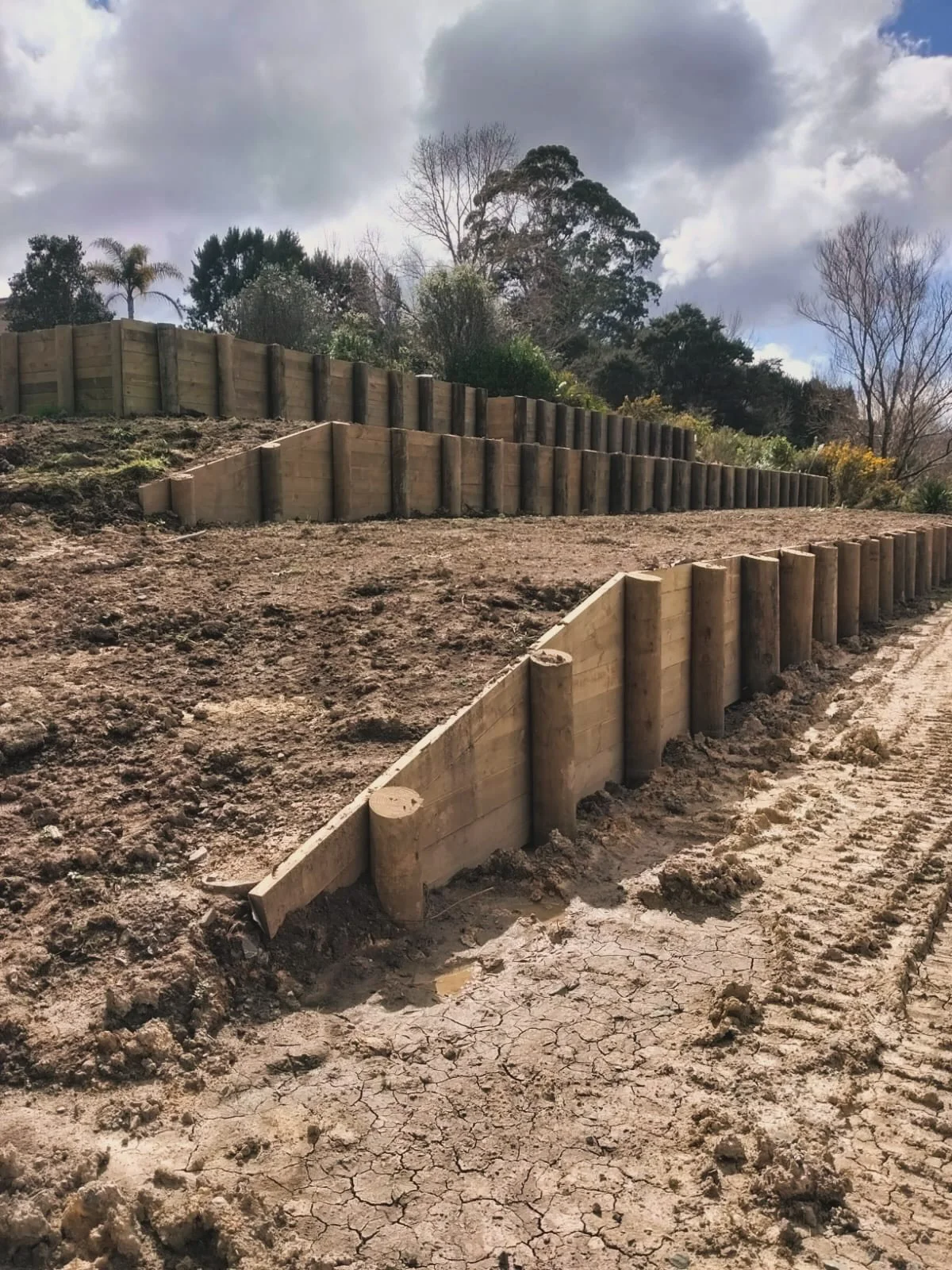 Three tiers of timber retaining walls built by Scorpion Hardscapes in Paremoremo