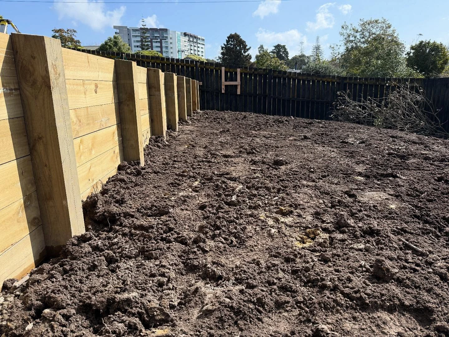 New timber retaining wall beside a soil yard