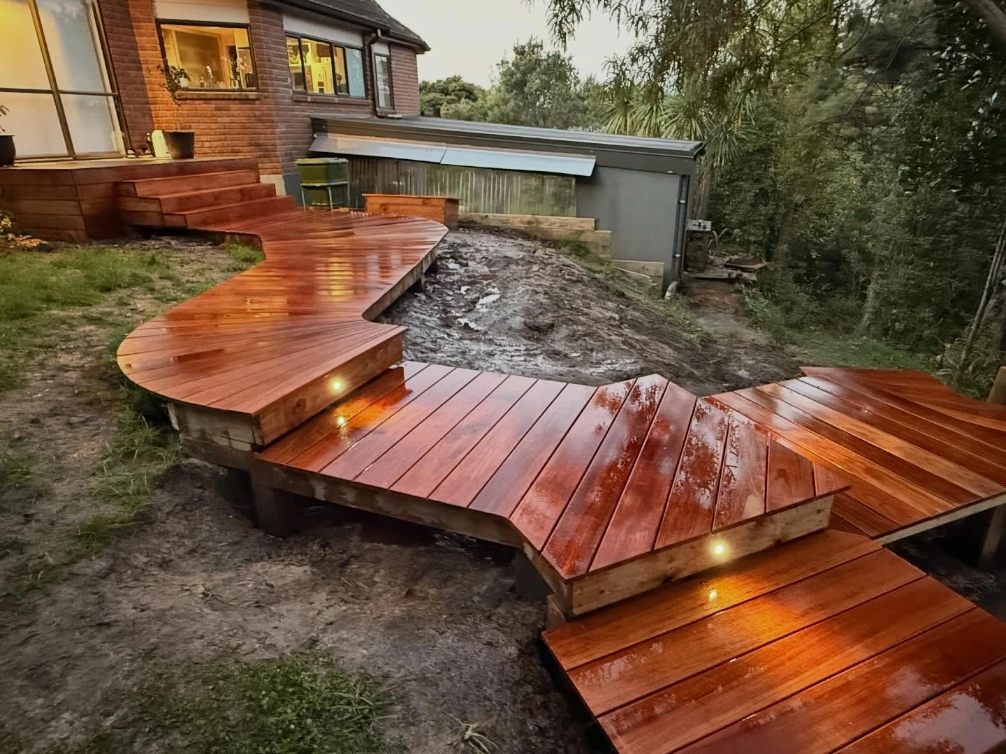 Winding Kwila deck and steps with step lights beside a house